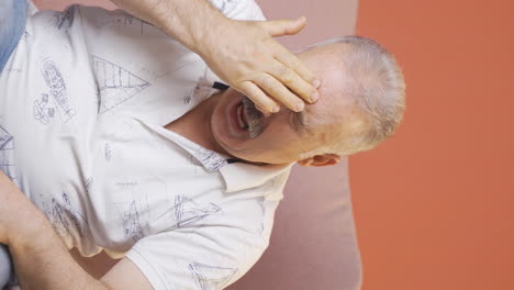 Vertical-video-of-Old-man-with-migraine-is-experiencing-pain.